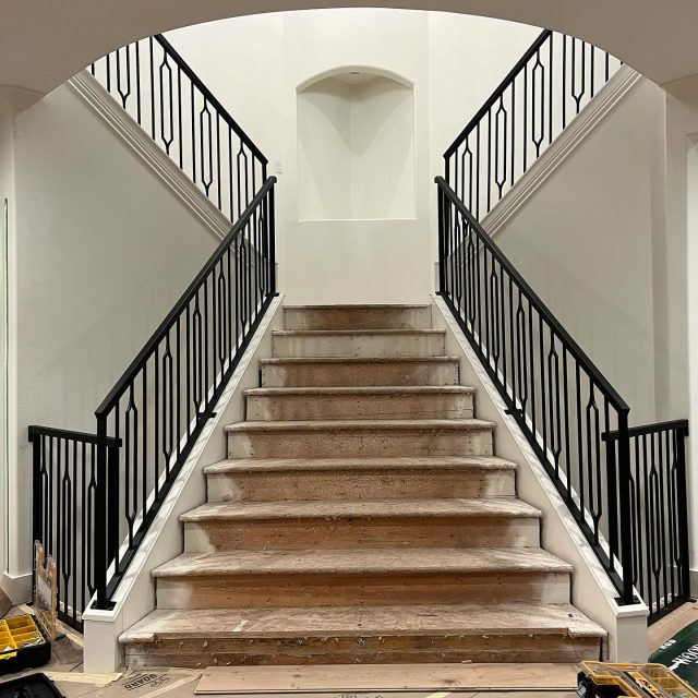 Black vertical metal stair railings installed in a contemporary interior space.