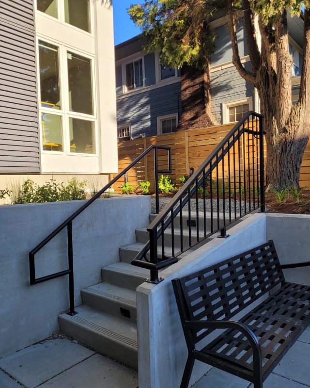 Black vertical railings with a matching handrail installed on an outdoor stairway.