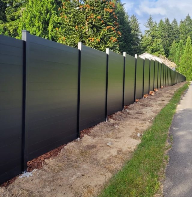Black aluminum privacy fence installed along a driveway for security and visual appeal.
