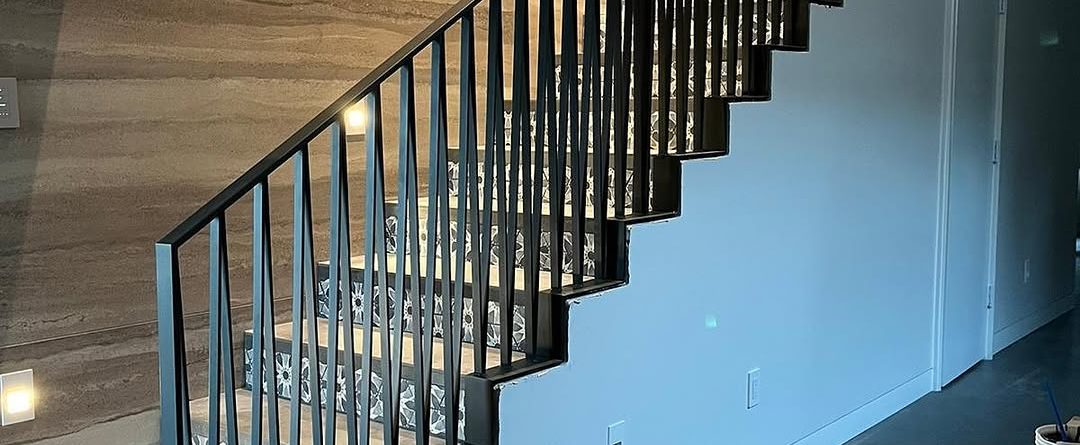 Custom black interior stair railings with vertical pickets installed on Mercer Island