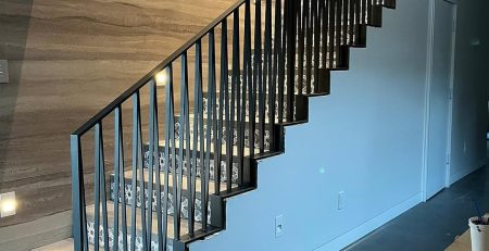 Custom black interior stair railings with vertical pickets installed on Mercer Island