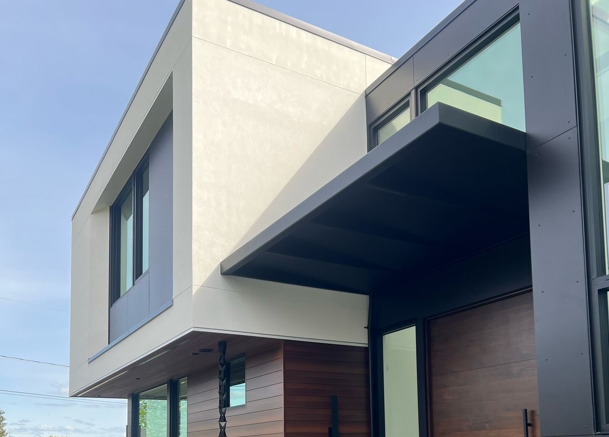 Custom fabricated black metal awning installed above a glass entryway of a modern home in Bellevue, Washington by Custom Railings WA