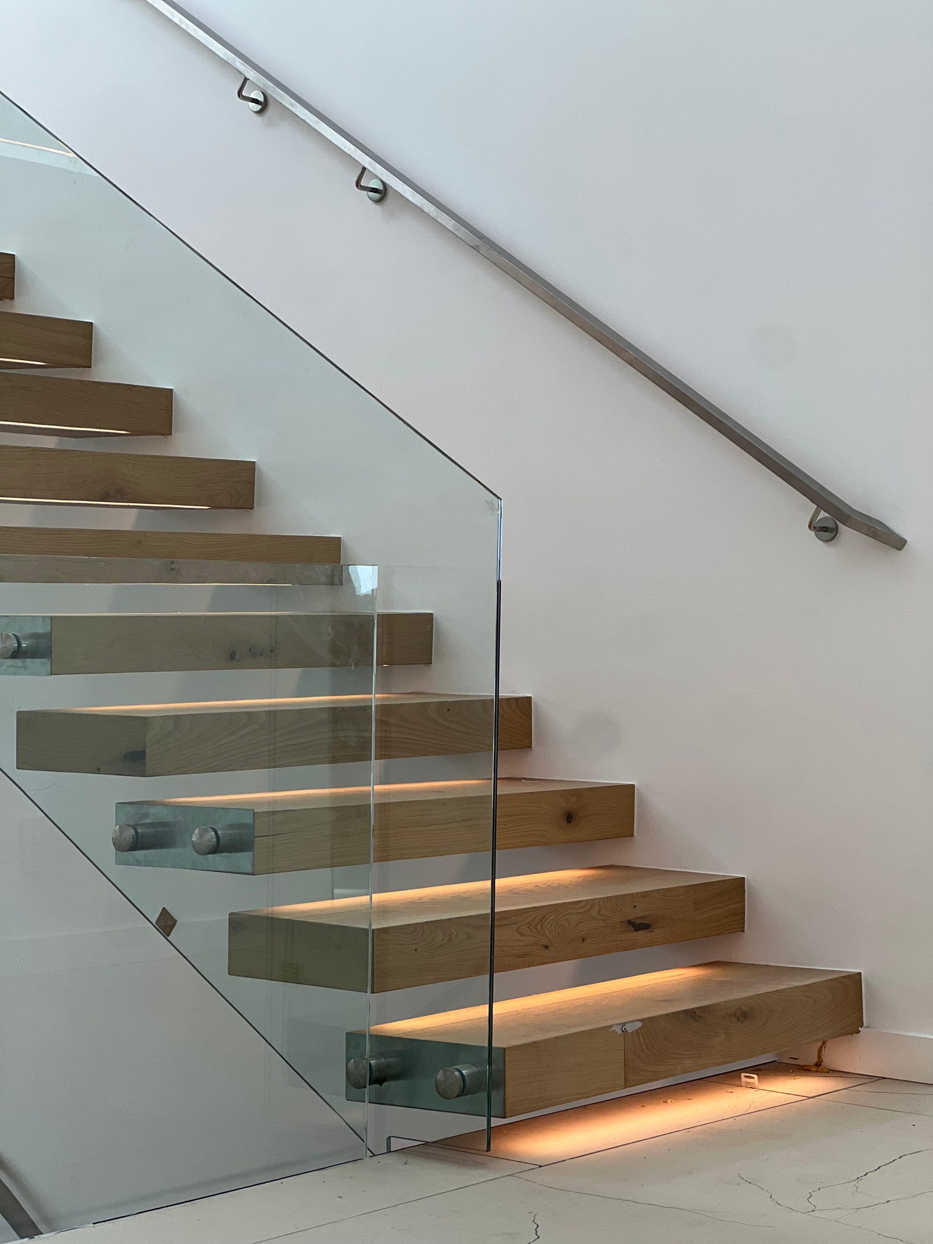 Tempered glass railing installed on modern floating wood staircase in Bellevue home