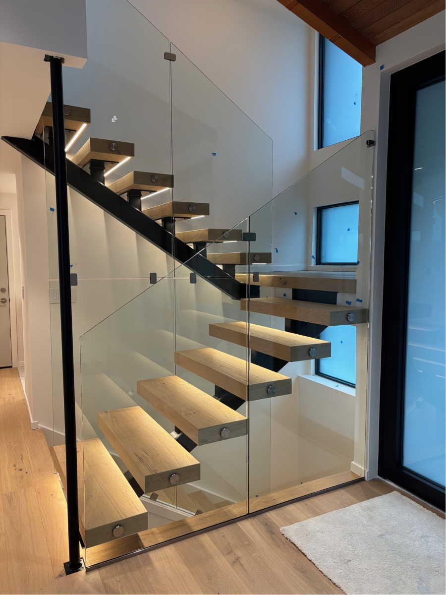 Floating stairs with full-height frameless glass railings in a modern Seattle home