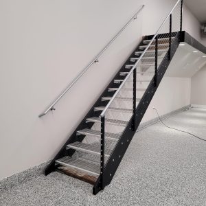 Metal stair railing with cable infill and grated treads in a commercial interior