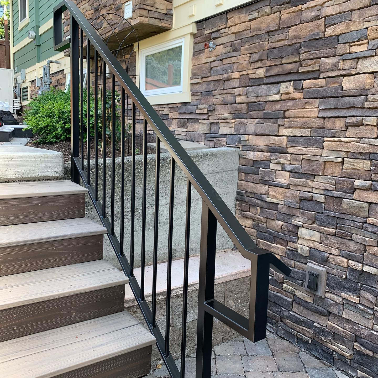 Black metal exterior stair railings with vertical pickets at a home entry in Seattle