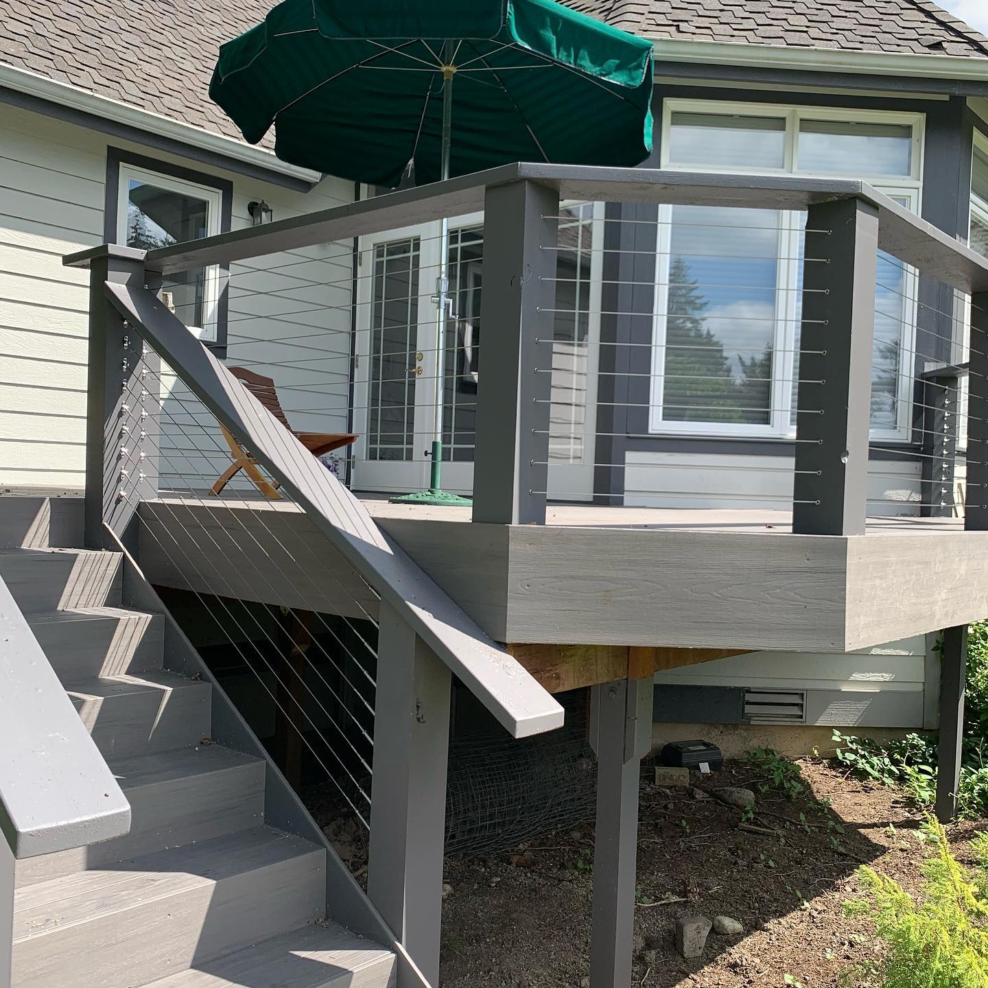 Exterior cable deck railing with gray posts and top rail on a backyard deck in Redmond, WA