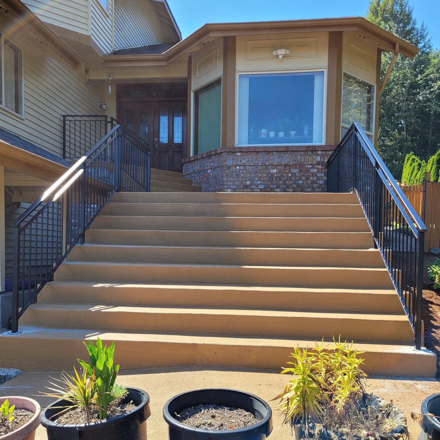 Black metal entry stair railings with vertical pickets on a wide front staircase in Tukwila, WA