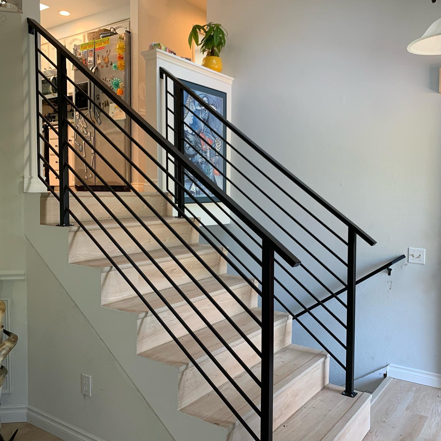 Modern interior stair railing with horizontal metal bars and square posts in Maple Valley