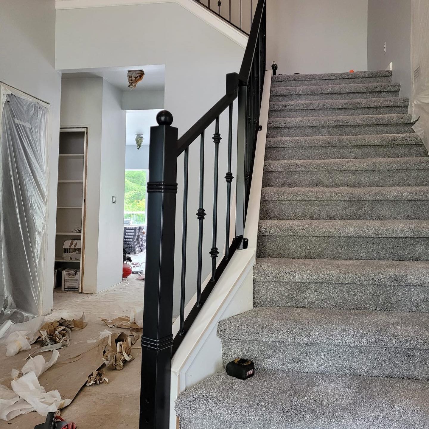 Traditional black interior stair railings with decorative iron balusters and a bold newel post in Olympia