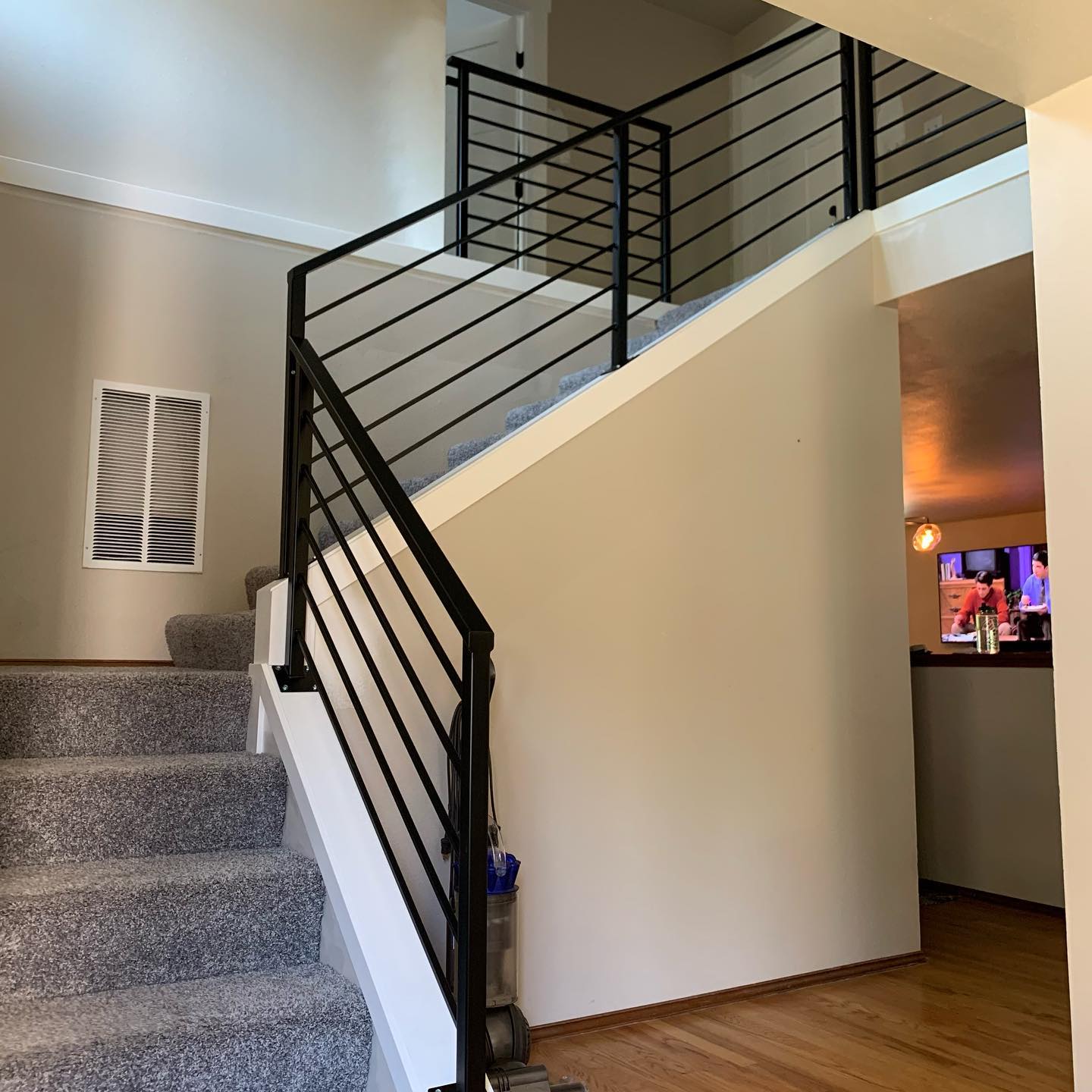 Black interior stair railing with horizontal bars and square newel posts in Renton, WA