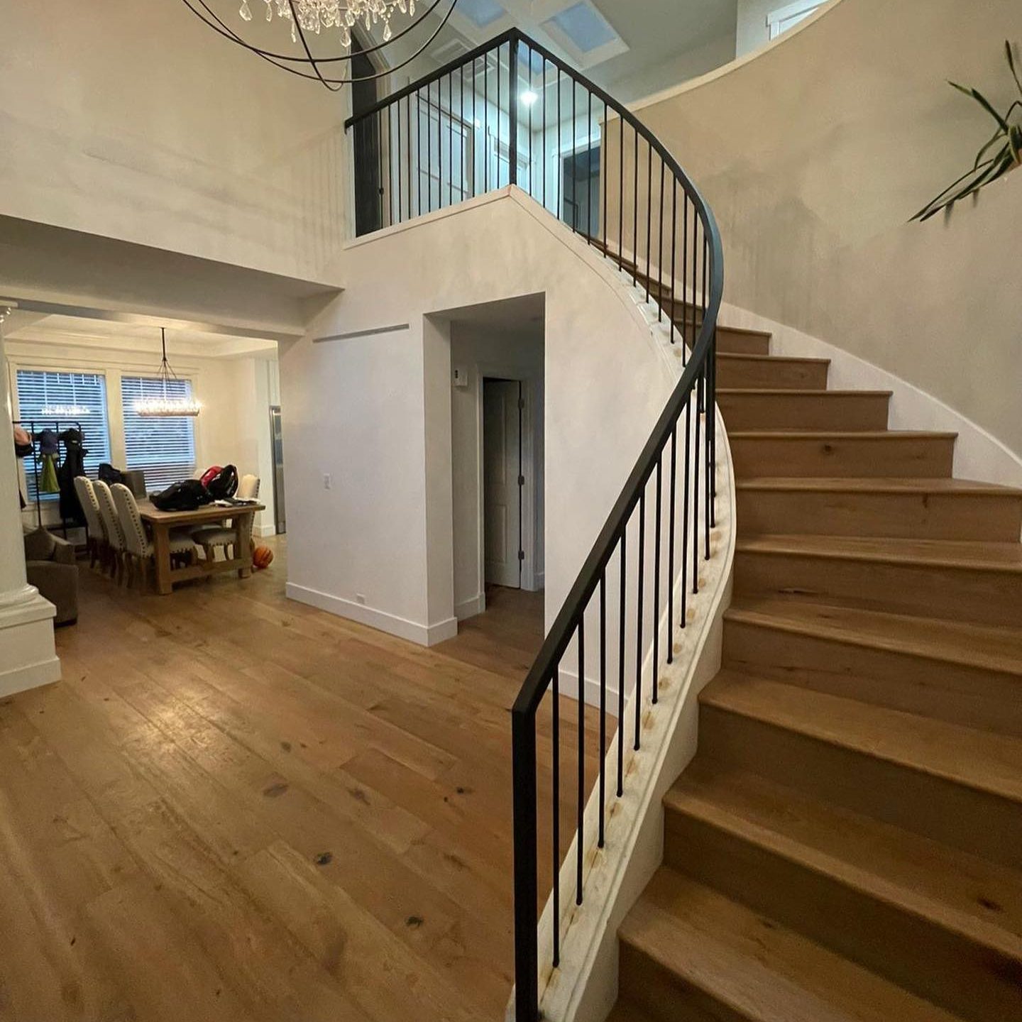 Curved interior railing wrapping a staircase with a smooth metal handrail