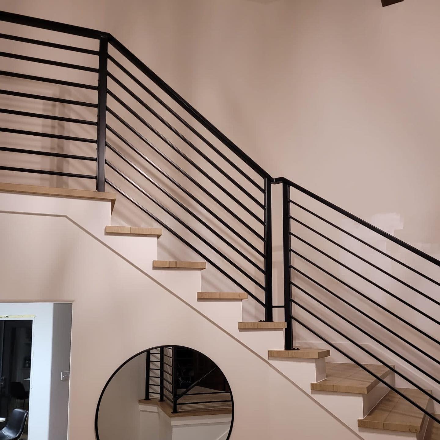 Modern interior railing with black steel frame and diagonal rail infill on staircase